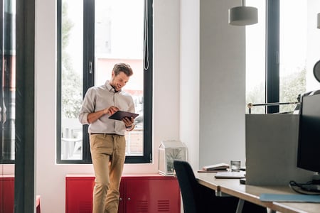 a tech sales professional working on a tablet in his office